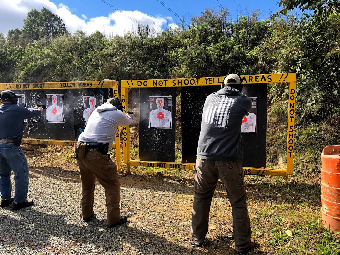 Two men are shooting at targets on a field.