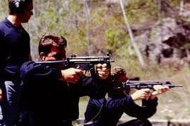 Two men are holding guns and aiming at something.