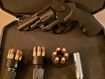 A gun and some bullets are laying on the ground