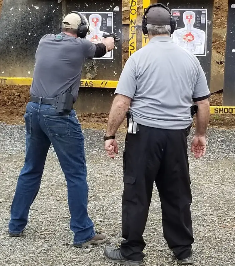 Two men are practicing shooting at a target.